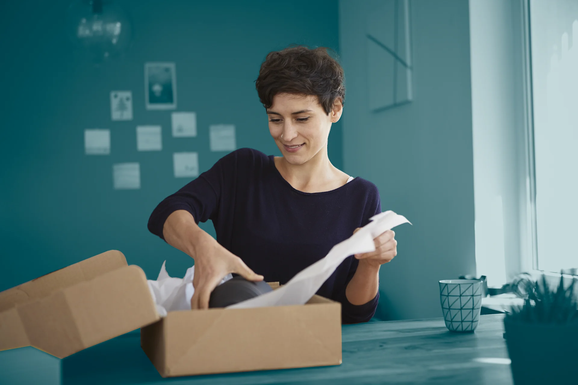 Woman packing parcel at home