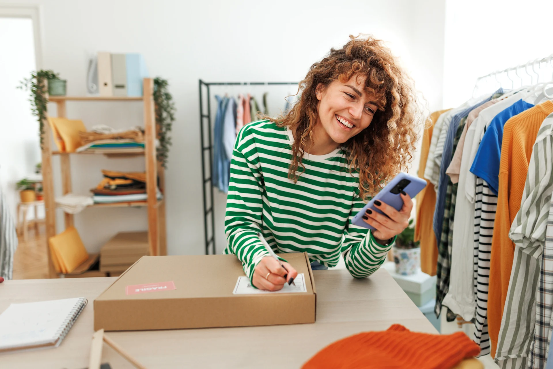 Woman smiling on phone leaning on parcel