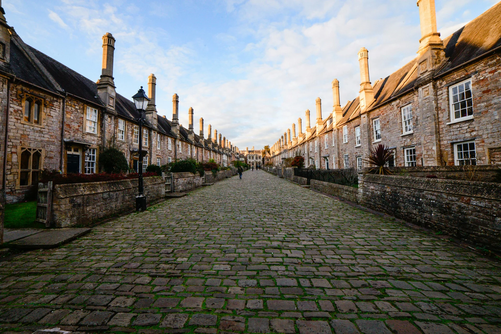 A narrow cobblestone street surrounded by brick houses