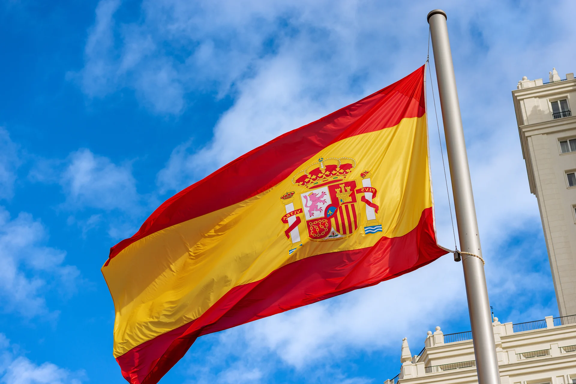 Spanish flag waving against blue sky