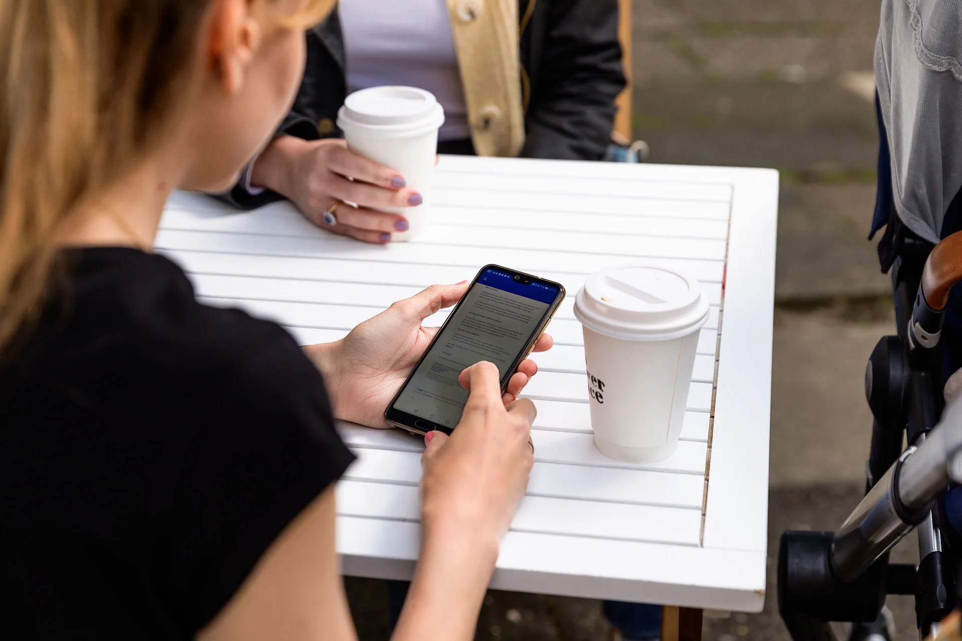Woman having coffee and checking her phone