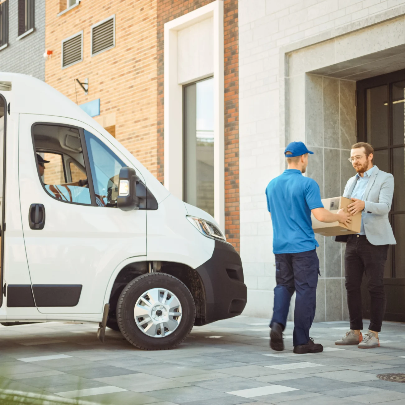 Delivery person handing over parcel with van in background