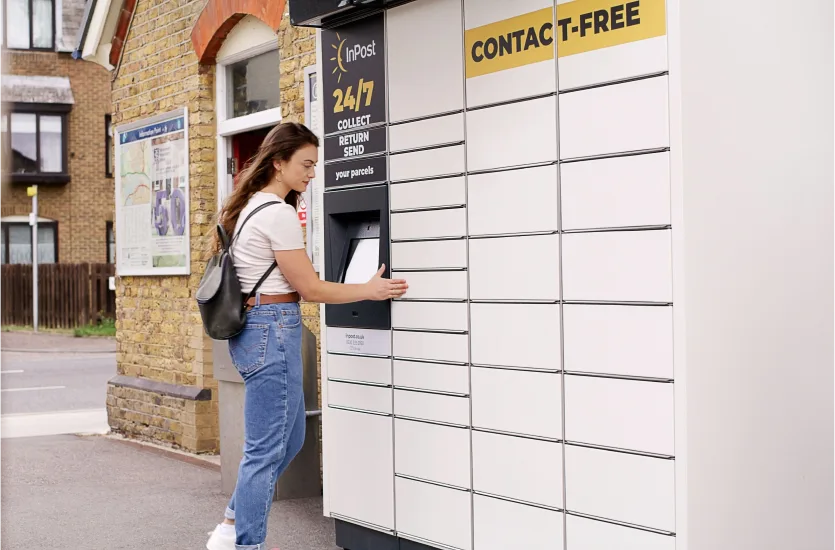 Woman picking up a package from an 24/7 Inpost locker