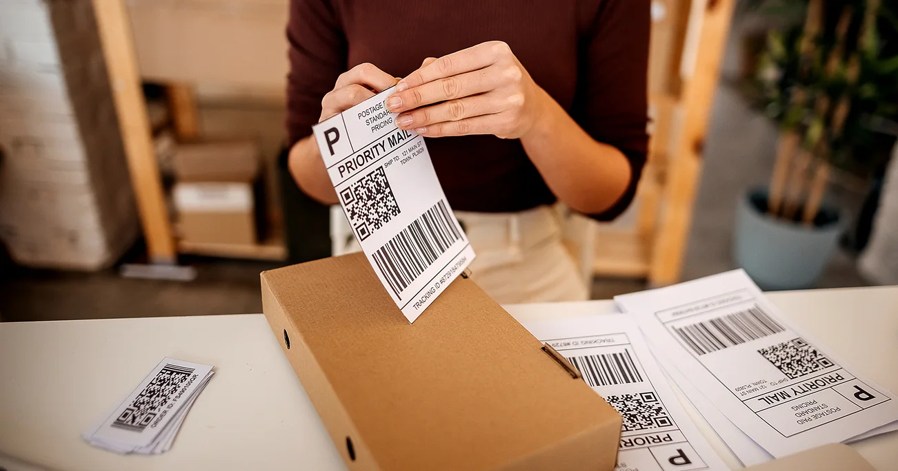 Woman peeling postage label for parcel