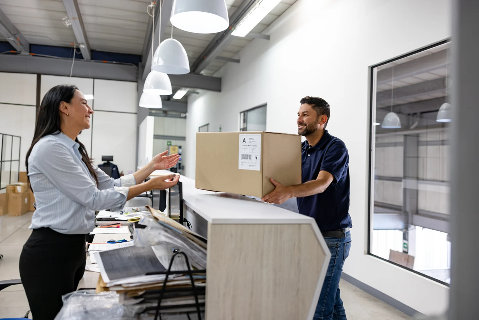 courier handing parcel over desk