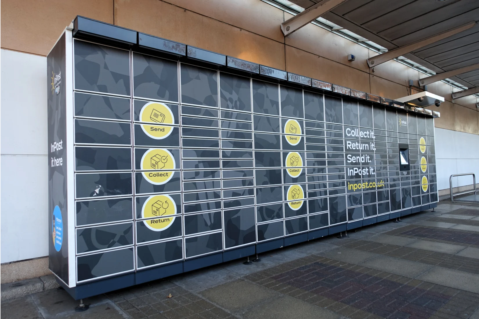 Long row of black InPost lockers in car park