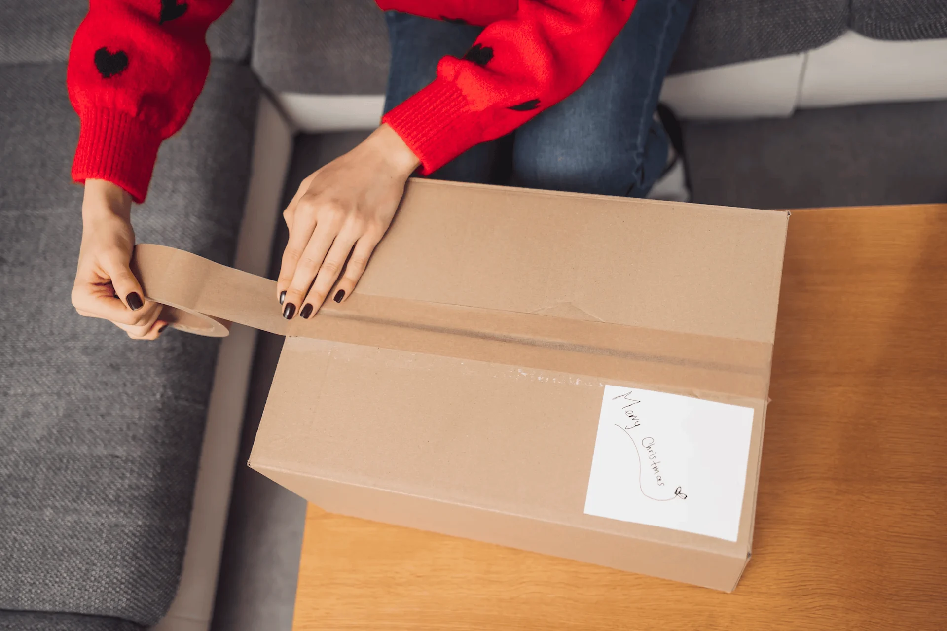 person sealing parcel at home