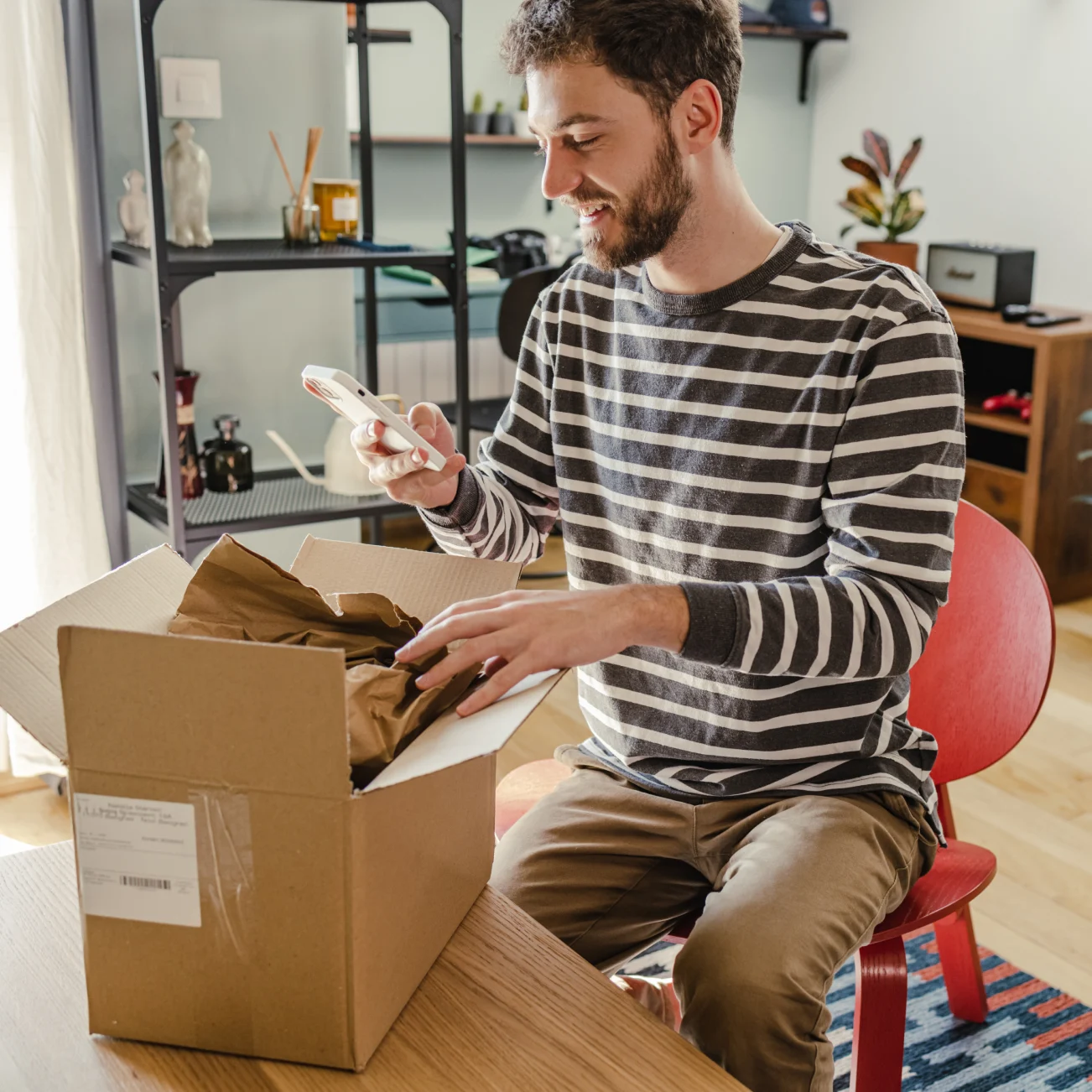 person smiling while opening parcel