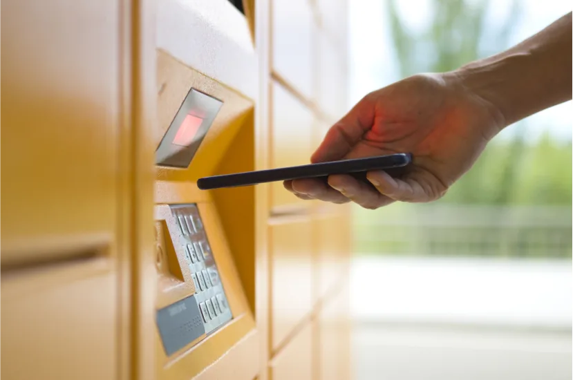 Woman picking up inpost package from an automated locker